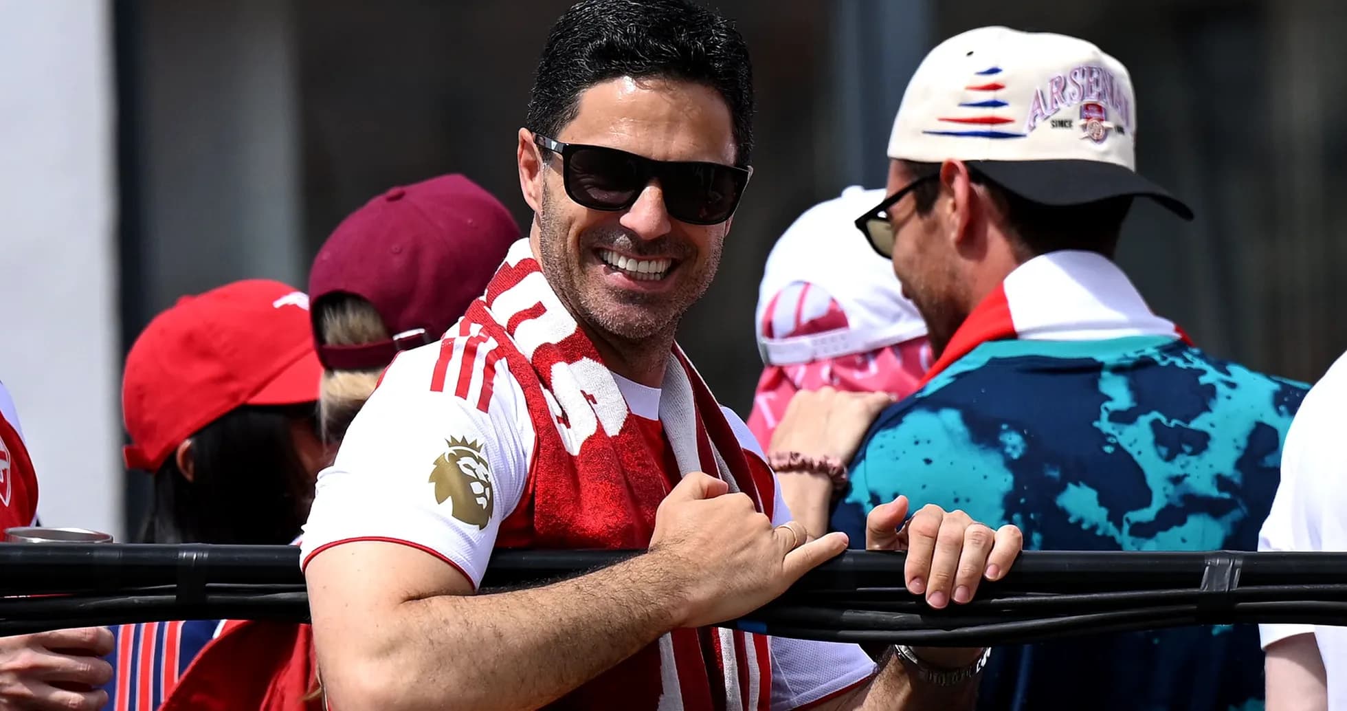 Hombre sonriendo con bufanda en evento deportivo Hombre sonriendo con bufanda en evento deportivo