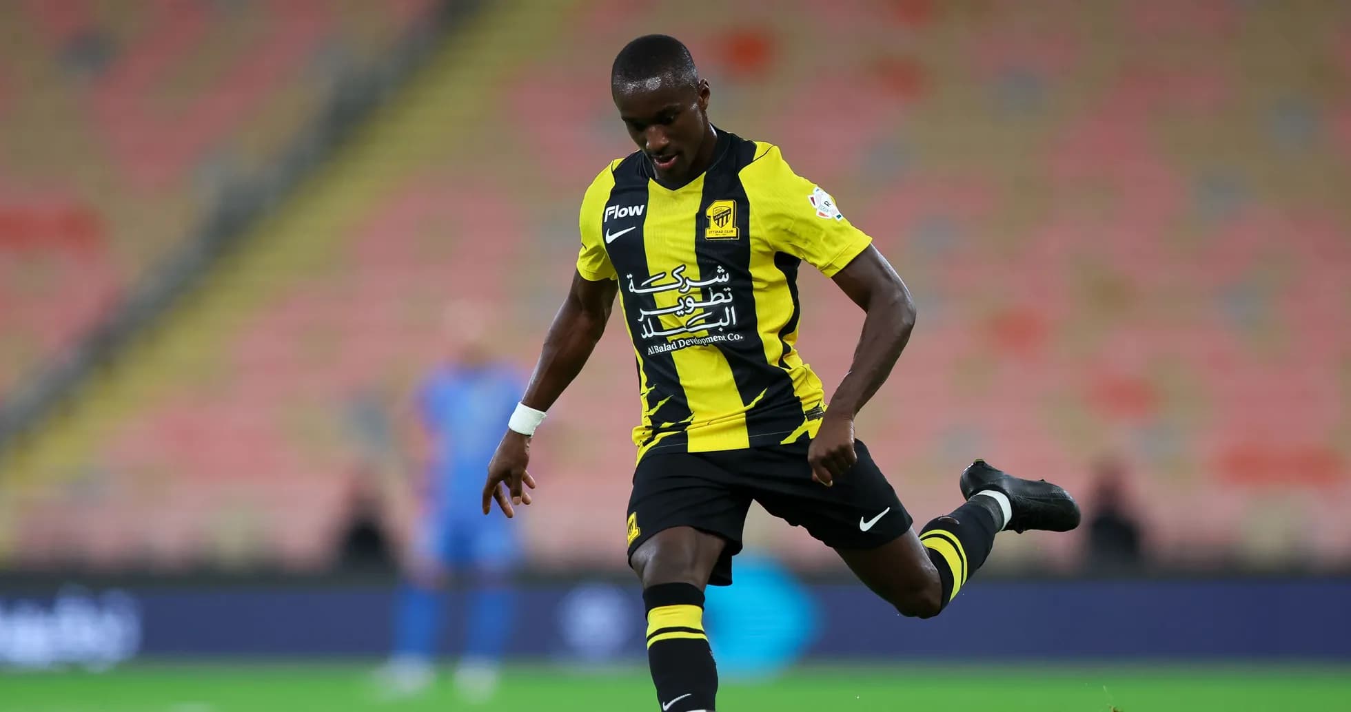 Jugador de Ittihad pateando el balón en el campo Jugador de Ittihad pateando el balón en el campo