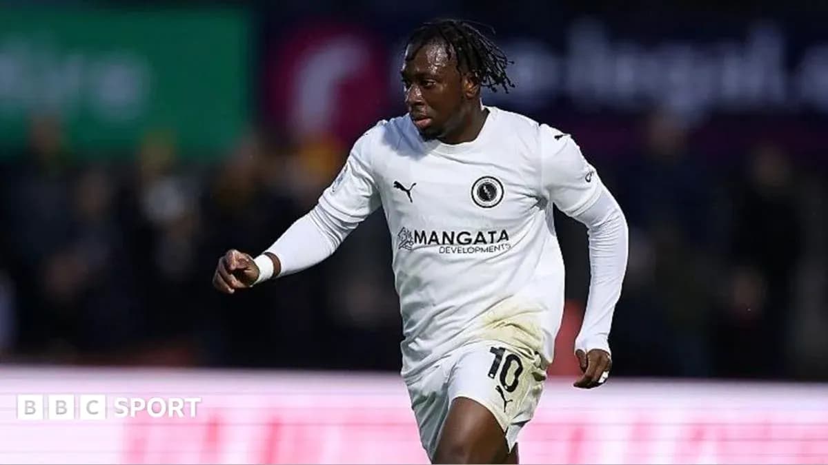 Jugador corriendo con camiseta blanca en el campo Jugador corriendo con camiseta blanca en el campo