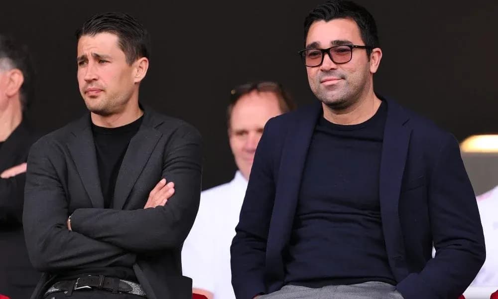 Dos hombres observando un evento deportivo desde la tribuna Dos hombres observando un evento deportivo desde la tribuna