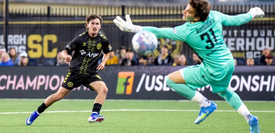 Jugador de Pittsburgh Riverhounds disparando a la portería Jugador de Pittsburgh Riverhounds disparando a la portería